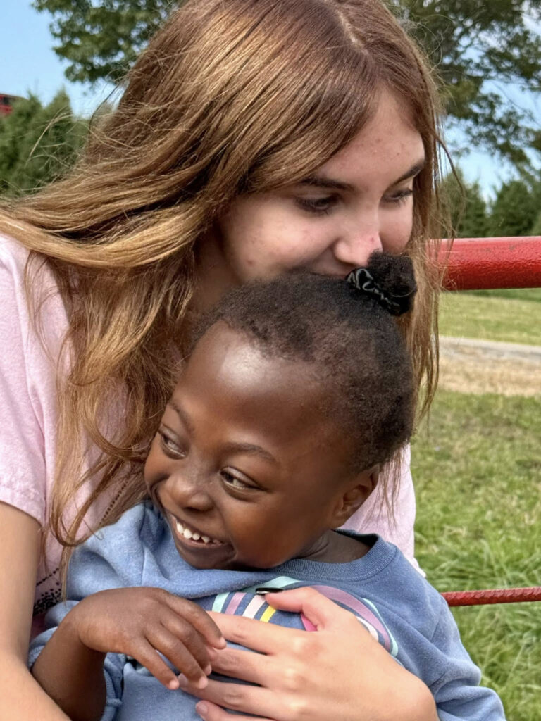 Teen girl hugging young girl